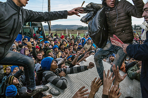 Idomeni, Greece - November 28, 2015: Barred refugees struggle for donation of water, blankets, diapers and few clothes as they complete their 10th day encamped by the train station in Idomeni, Greece, without permission to cross the border into the Macedonian town of Gevgelija. Hundreds of thousands of refugees, mostly from Afghanistan, Iraq and Syria, fled their homes, risking their lives in dangerous boat trips, illegal border crossings and long bus and train journeys, seeking asylum and a decent life in Western Europe and Scandinavia. The latest UN report from January 2015 estimated that more than 220,000 people had become fatal victims of the endless war in Syria. CREDIT: Photo by Mauricio Lima for The New York Times